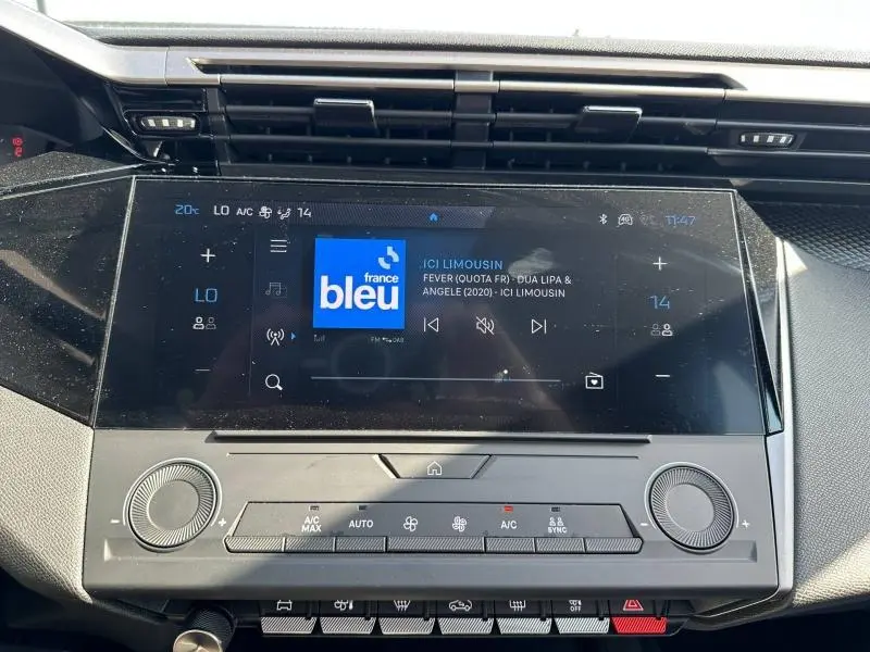 Vue rapprochée de l’écran tactile central et des commandes de climatisation de la Peugeot 308 bleu, intérieur moderne et épuré.