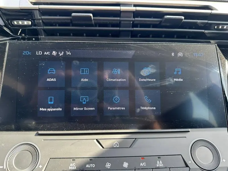 Écran tactile central de la Peugeot 308 bleu, affichant les menus de climatisation et médias en vue frontale rapprochée.