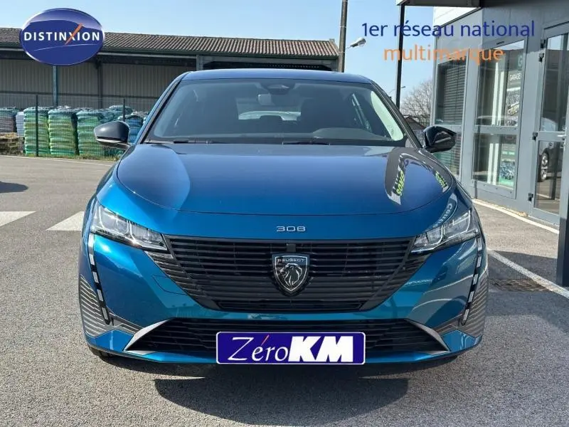 Vue frontale d'une Peugeot 308 bleu Obsession 2025 avec calandre noire et feux LED distinctifs.