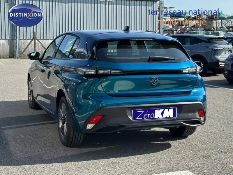 Vue 3/4 arrière d'une Peugeot 308 bleu Obsession 2025 avec feux arrière LED et jantes alu visibles.