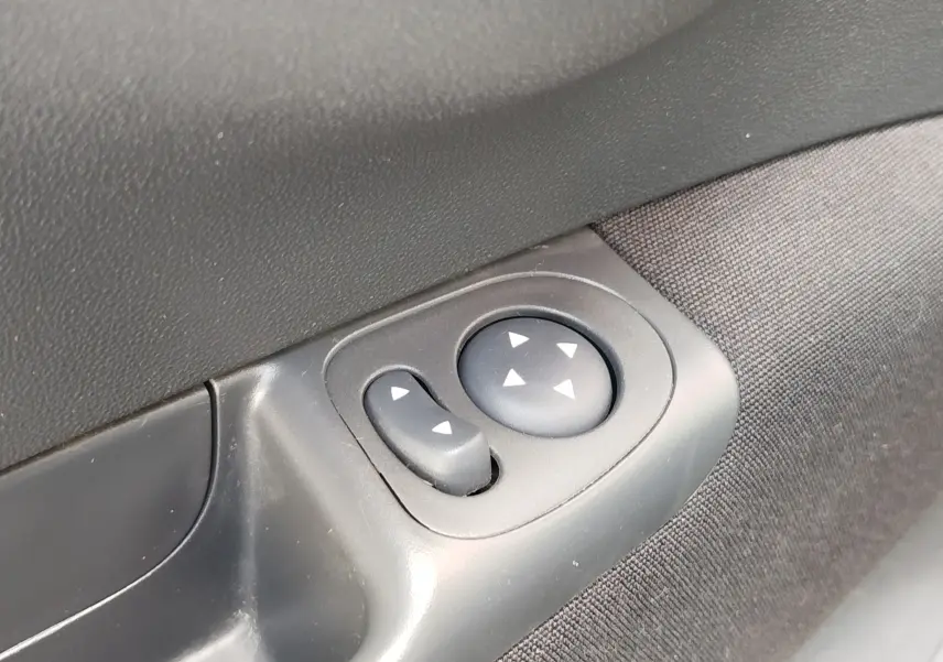 Commande électrique des rétroviseurs sur la porte intérieure côté conducteur d'une Fiat 500 Lounge blanche.