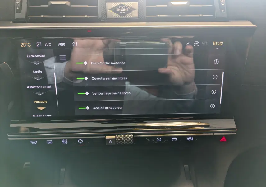 Vue rapprochée de l'écran tactile central du DS7 gris laqué, affichant les réglages d'ouverture mains libres et porte motorisée.