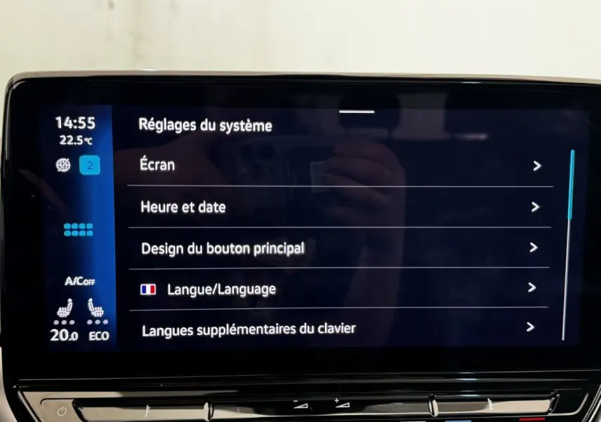 Écran tactile central affichant les réglages système dans un Volkswagen ID.4 blanc, vue intérieure frontale.