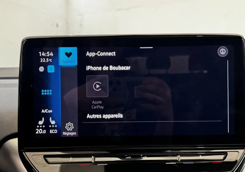 Écran tactile central du Volkswagen ID.4 blanc, affichant la connexion Apple CarPlay et les réglages climatisation.