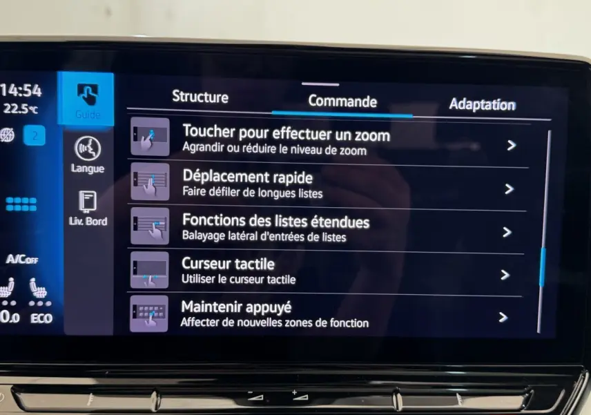 Écran tactile intérieur du Volkswagen ID.4 blanc, affichant les commandes de zoom et navigation du système multimédia.