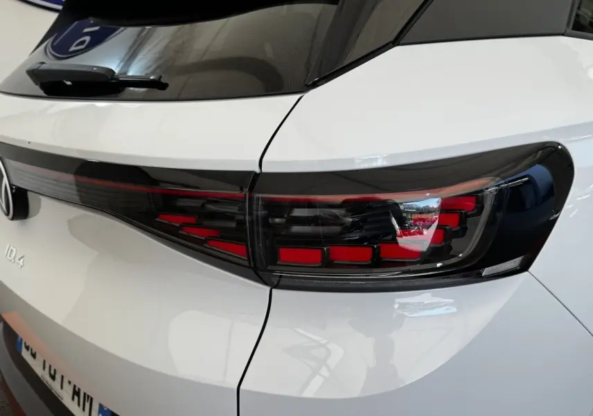 Gros plan sur le feu arrière droit noir et rouge du Volkswagen ID.4 blanc, vue arrière côté droit.