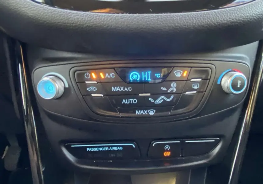 Panneau de commande de la climatisation automatique du Ford B-MAX blanc, avec affichage digital et réglages tactiles.
