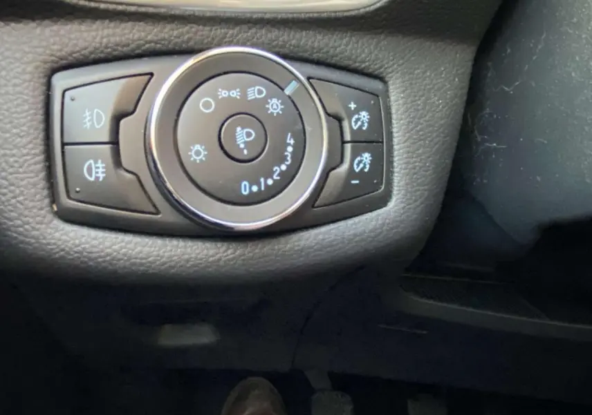 Gros plan sur la commande d’éclairage intérieure du tableau de bord d’une Ford B-MAX blanche de 2014.