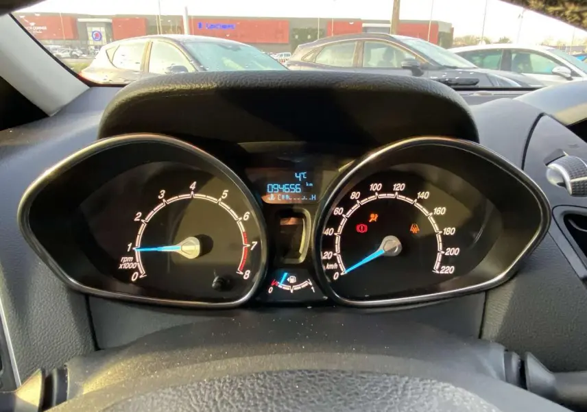 Vue intérieure du tableau de bord du Ford B-MAX blanc 2014, affichant compte-tours, compteur de vitesse et écran digital.