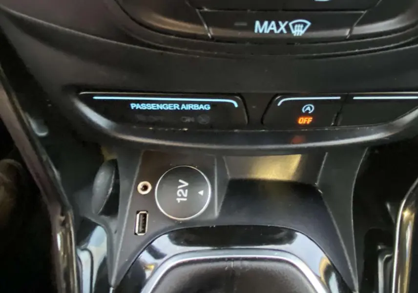Vue rapprochée de la console centrale du Ford B-MAX blanc 2014, avec prise 12V et port USB visibles.