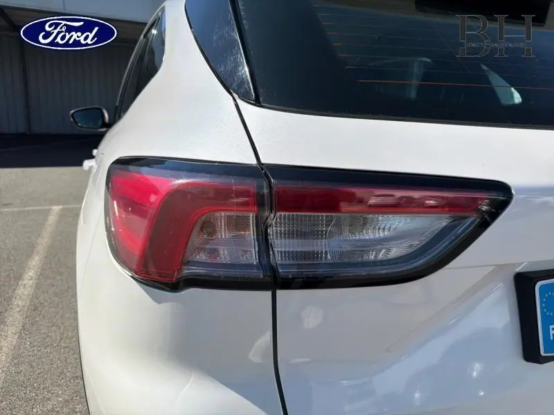 Gros plan sur le feu arrière droit d’un Ford Kuga blanc Glacier 2023, soulignant ses lignes modernes et épurées.