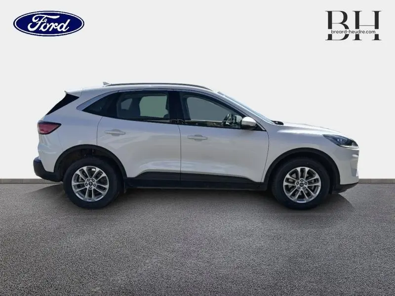 Vue de profil droit du Ford Kuga blanc Glacier 2023 avec jantes alliage et barres de toit visibles.