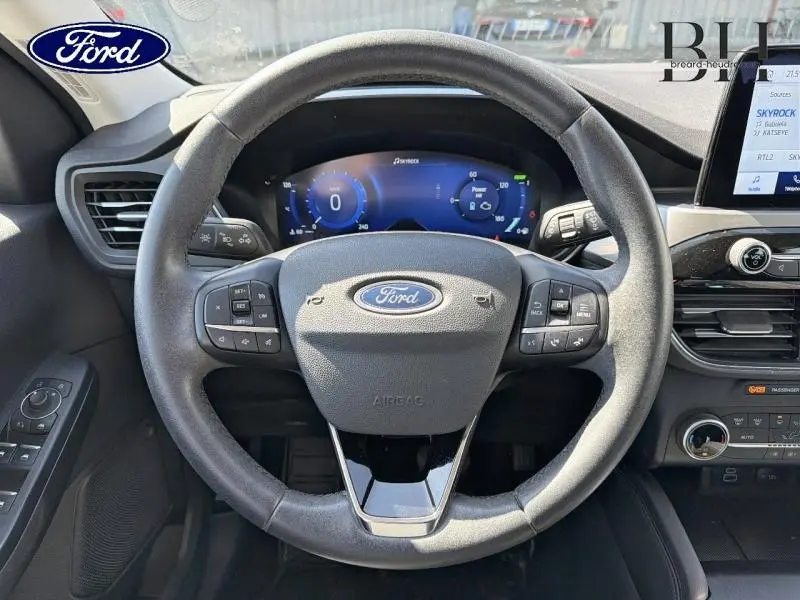 Vue frontale du volant cuir multifonction du Ford Kuga 2023 avec tableau de bord numérique et écran tactile.