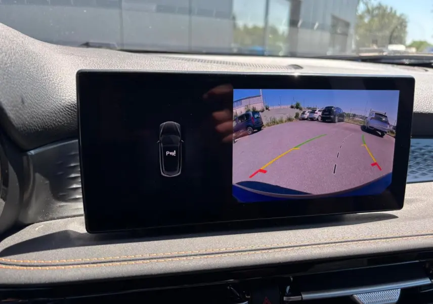 Écran tactile intérieur affichant la caméra de recul avec lignes de guidage du SUV Alfa Romeo Tonale blanc.