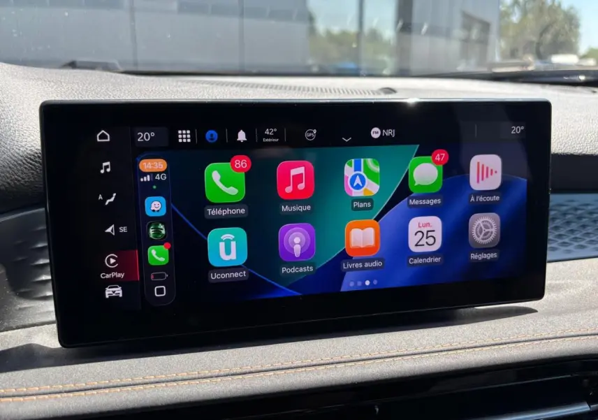 Écran tactile central affichant Apple CarPlay dans l'habitacle d'une Alfa Romeo Tonale 2025 blanche.