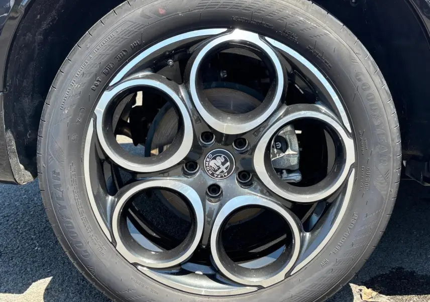 Gros plan sur la roue avant droite d’un véhicule blanc, mettant en valeur le pneu Goodyear et la jante en alliage.