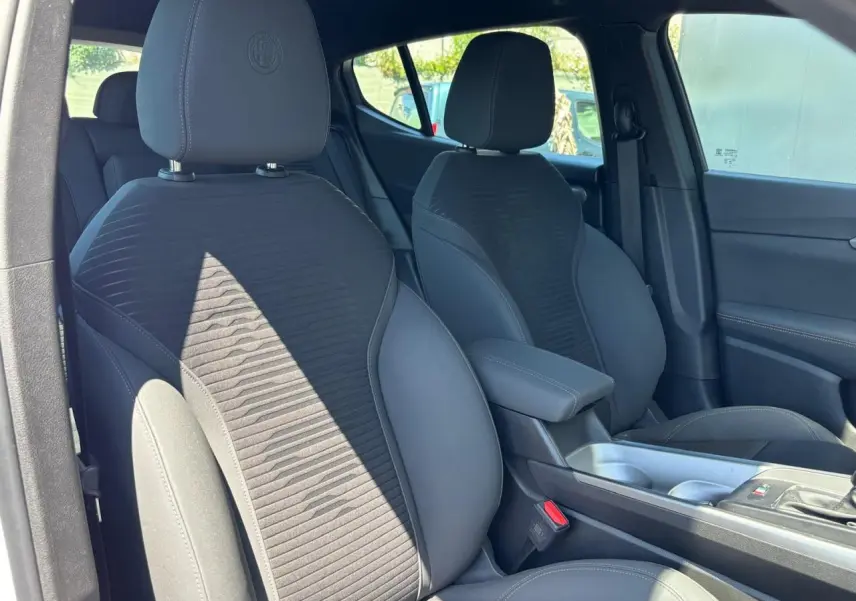 Vue intérieure côté droit de l'Alfa Romeo Tonale 2025, sièges noirs avec logo Alfa Romeo brodé sur les appuie-têtes.