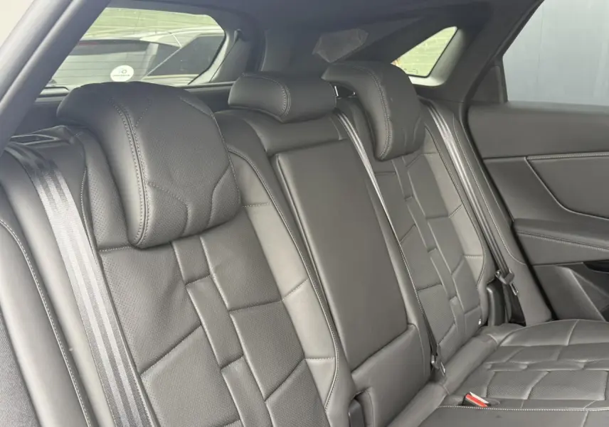 Vue intérieure sur la banquette arrière en cuir noir Basalte du DS7 2025, avec ceinture de sécurité et vitres latérales.