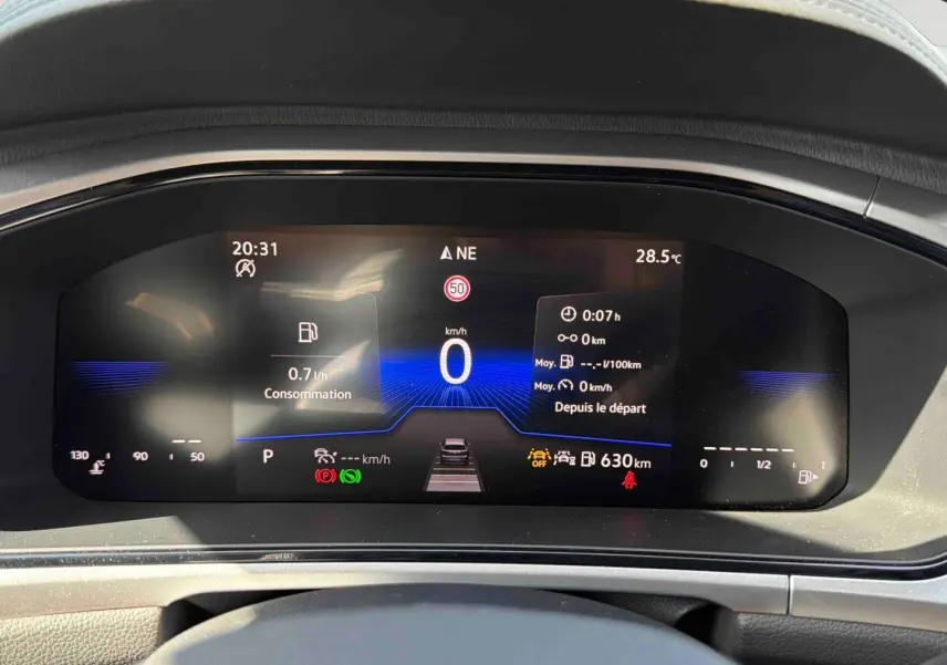 Vue rapprochée du combiné d'instruments digital du Volkswagen T-Roc 2.0 TDI noir, affichant la vitesse et la consommation.