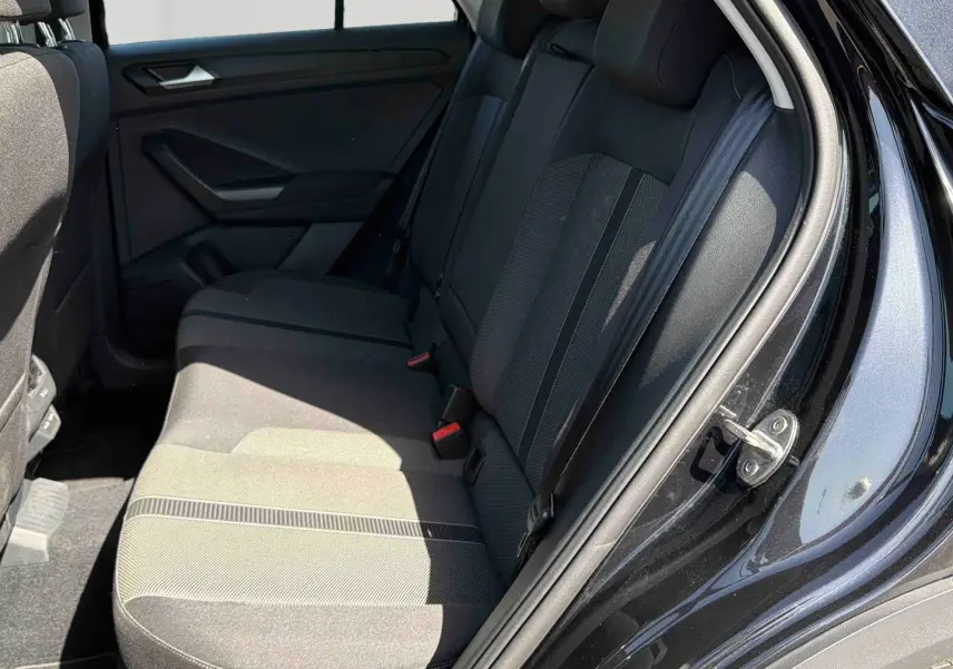 Vue intérieure arrière côté droit du Volkswagen T-Roc noir, montrant les sièges arrière en tissu gris foncé.