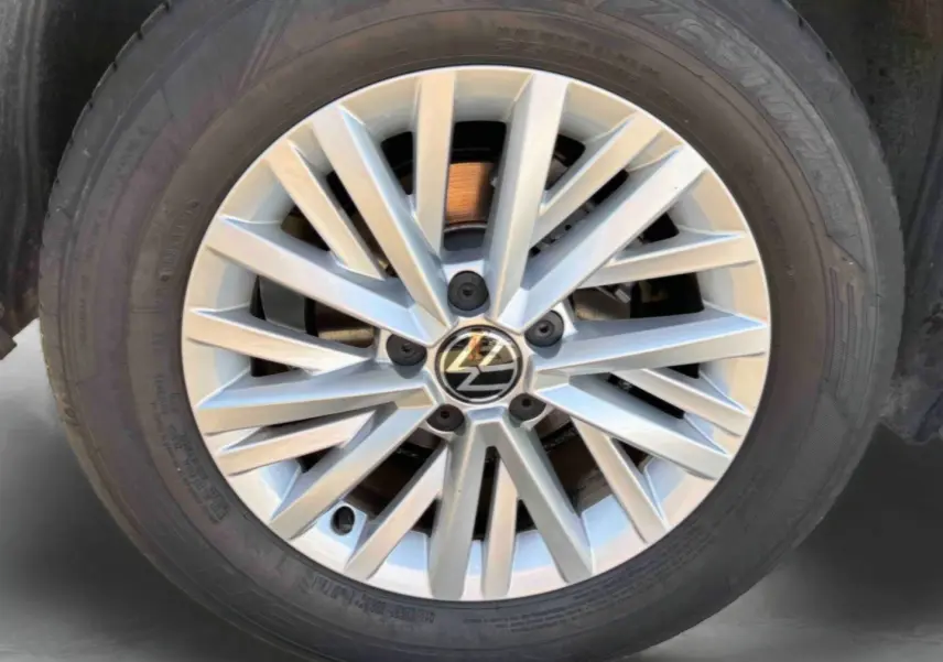 Gros plan sur la jante en alliage léger 16'' Chester argentée du Volkswagen T-Roc noir, avec logo VW central visible.