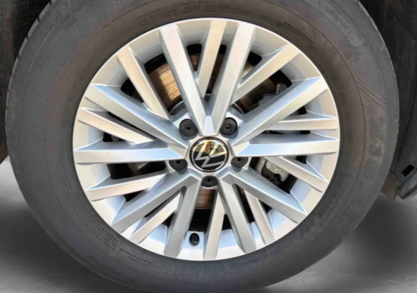 Gros plan sur la jante alliage 16'' Chester argentée avec logo Volkswagen au centre du Volkswagen T-Roc noir.