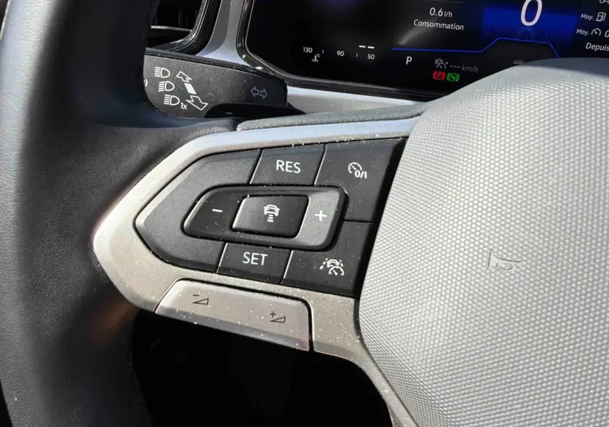 Gros plan sur le volant cuir multifonctions noir du Volkswagen T-Roc 2.0 TDI 150 DSG7 avec commandes de régulateur adaptatif.