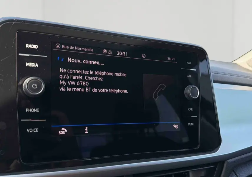 Écran tactile central du Volkswagen T-Roc 2025 affichant la connexion Bluetooth, vue intérieure côté passager.