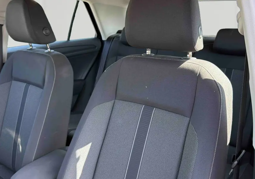 Gros plan sur les sièges avant gris foncé et tissu clair du Volkswagen T-Roc 2025, intérieur spacieux et lumineux.