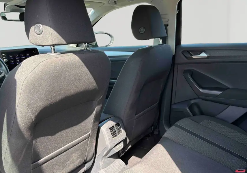 Vue arrière intérieure du Volkswagen T-Roc noir 2025, montrant les sièges avant et la banquette arrière en tissu.