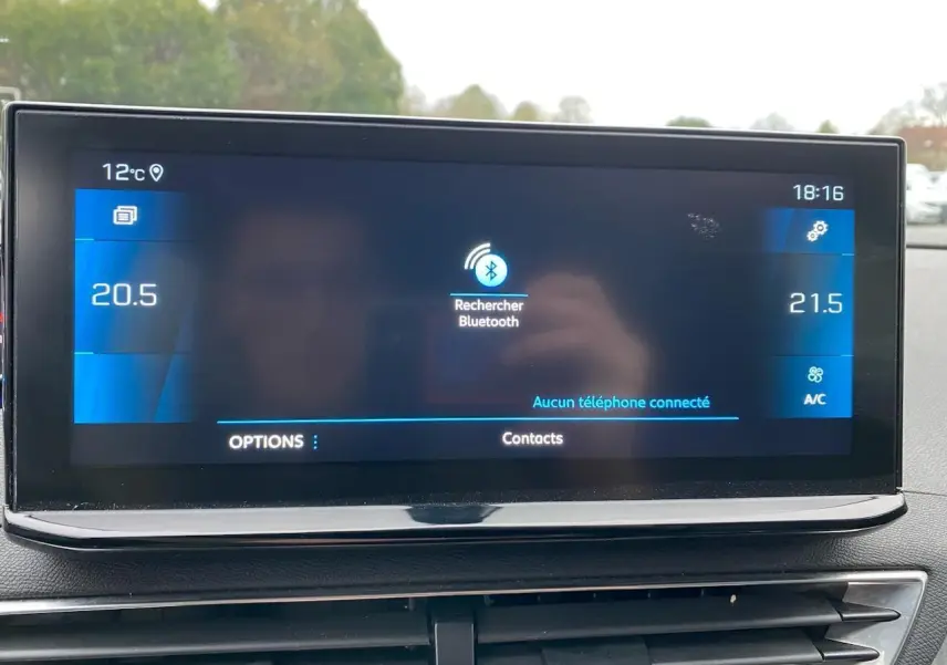 Écran tactile central du Peugeot 3008 gris platinium affichant la recherche Bluetooth et la température intérieure.