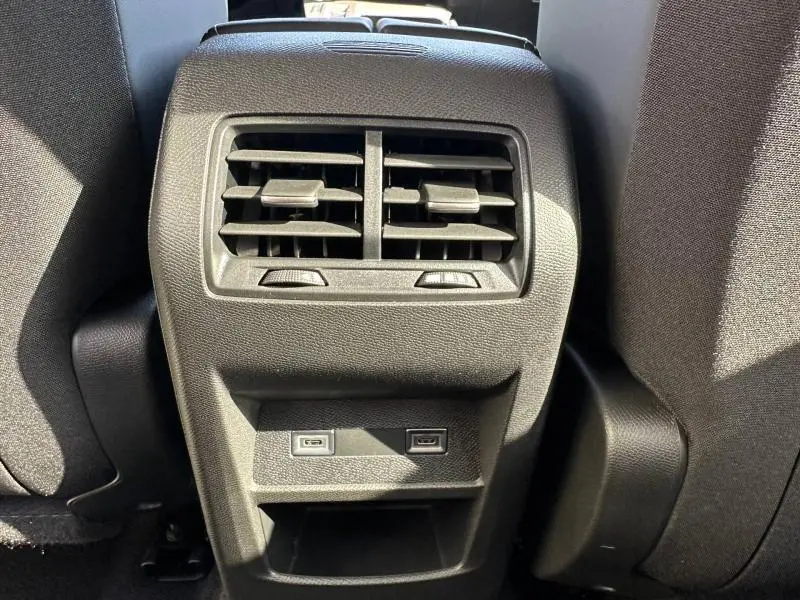 Vue rapprochée des aérateurs arrière et ports USB entre les sièges avant d’une Peugeot 308 gris Artense.