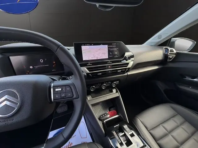 Vue intérieure côté conducteur du Citroën C4 Hybrid 145 gris Mercury, avec tableau de bord numérique et écran tactile central.