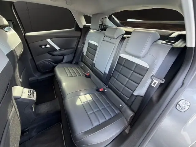 Vue intérieure sur la banquette arrière cuir bicolore gris clair et foncé du Citroën C4 Hybrid 145 e-DCS6 MAX 2025.