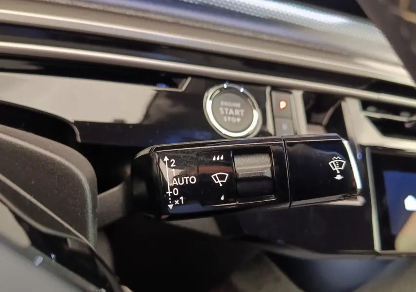 Gros plan sur la commande des essuie-glaces côté gauche du tableau de bord du Peugeot 3008 bleu hybride 2025.