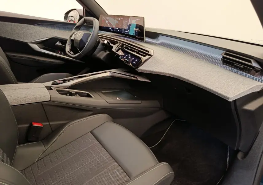 Vue intérieure côté passager du Peugeot 3008 1.2 HYBRID 136 GT avec tableau de bord gris clair et sièges noirs.