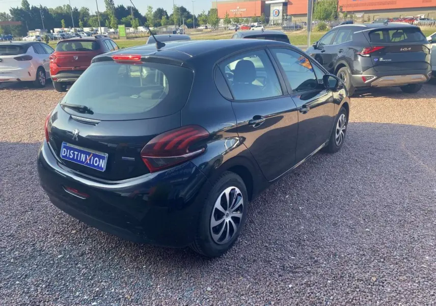 Vue 3/4 arrière droite d'une Peugeot 208 noire 2016 avec jantes acier et feux arrière distinctifs.
