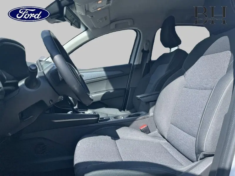 Vue intérieure côté conducteur du Renault Arkana 1.6 E-Tech blanc perle, sièges tissu noir titane et volant multifonction.