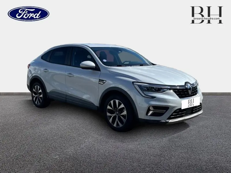 Renault Arkana blanc perle en 3/4 avant droit, SUV hybride avec jantes alliage et vitres teintées.