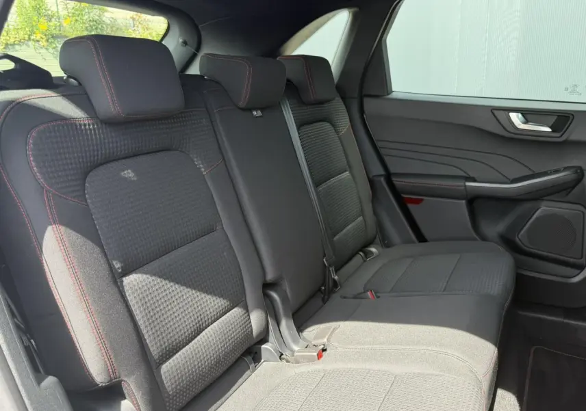 Vue intérieure côté droit des sièges arrière noirs avec surpiqûres rouges du Ford Kuga 2023 finition ST-Line.