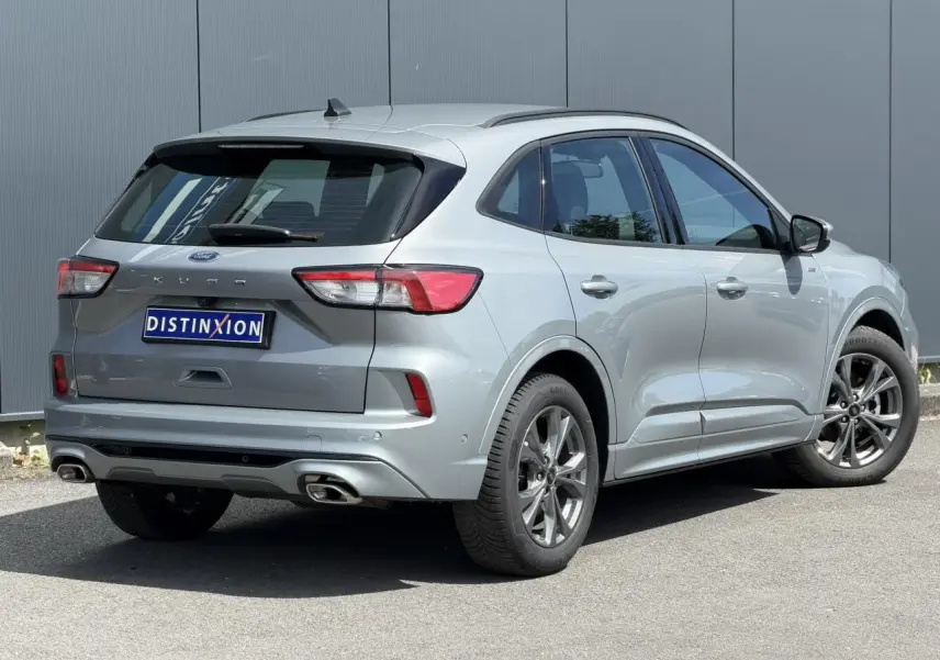 Vue 3/4 arrière droite du Ford Kuga gris Solar 2023 avec double sortie d’échappement et jantes alliage 18 pouces.