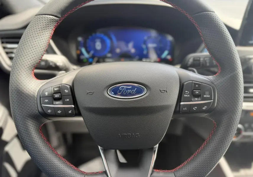 Volant perforé avec surpiqûres rouges du Ford Kuga 2.0 EcoBlue 120 BVA ST-Line, vue frontale intérieure.