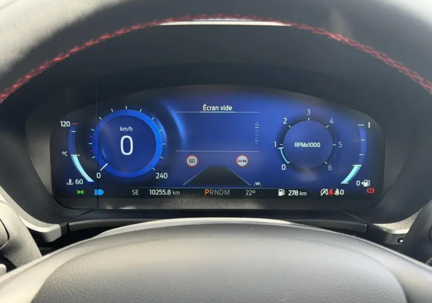 Vue rapprochée du combiné d'instrumentation numérique bleu du Ford Kuga 2023, affichant vitesse et compte-tours.