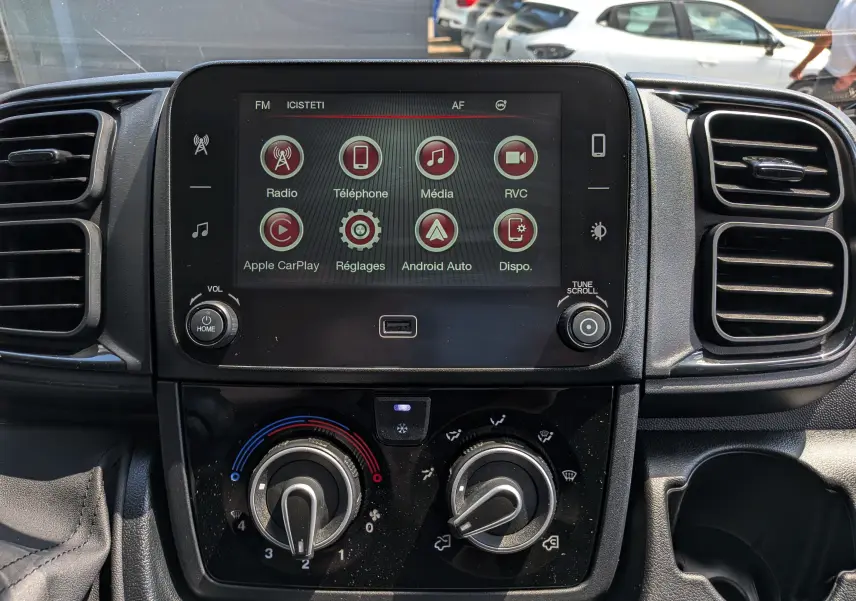Vue rapprochée de l’écran tactile et des commandes de climatisation du Fiat Ducato Fourgon blanc, version 2026.