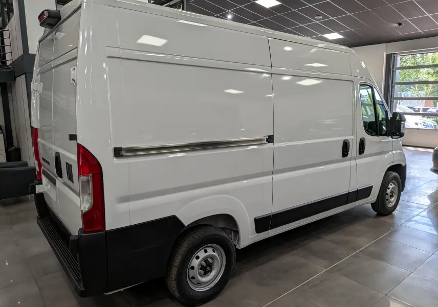Vue 3/4 arrière droite du fourgon blanc FIAT Ducato M H2 3.3T, avec portes latérales et feux arrière rouges visibles.