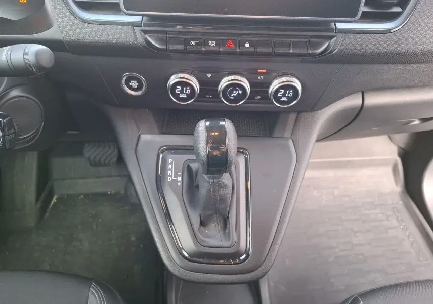 Gros plan sur la console centrale du Renault Kangoo Pro 2025 avec levier de boîte auto et commandes climatisation.