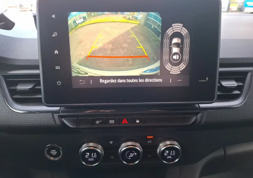 Vue intérieure du tableau de bord du Renault Kangoo Pro 2025, écran tactile affichant la caméra de recul et climatisation automatique.