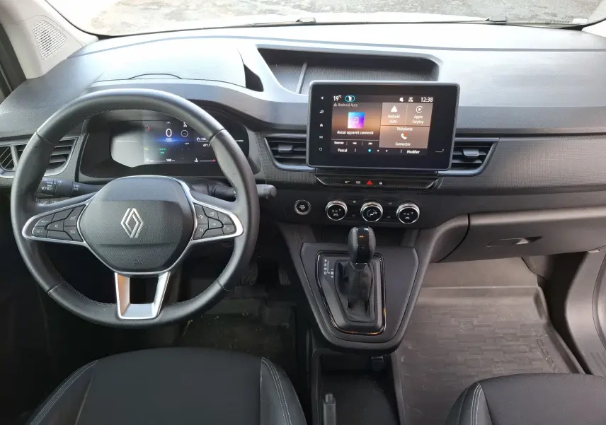 Vue intérieure frontale du tableau de bord du Renault Kangoo Pro blanc, avec écran tactile central et volant multifonction.