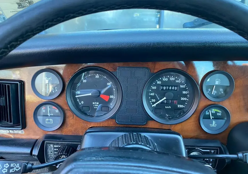 Tableau de bord en bois du Jaguar XJ6 Série 3 4.2 Sovereign 1985 avec compteurs ronds et volant noir.