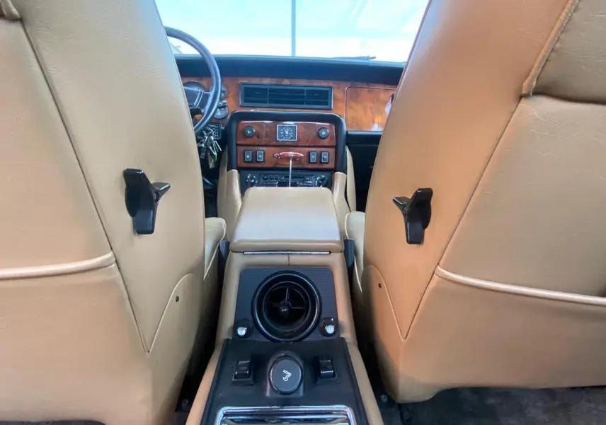 Vue intérieure arrière de la Jaguar XJ6 Série 3 4.2 Sovereign 1985, cuir beige et tableau de bord en bois marron.